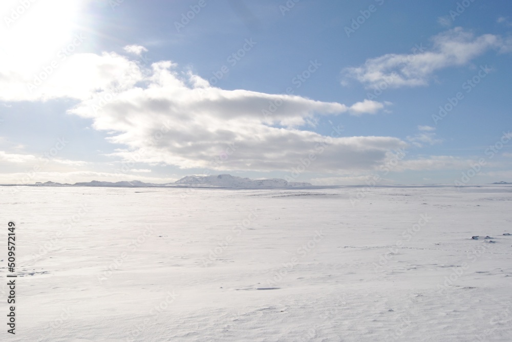 snowy landscape with blue sky and clouds