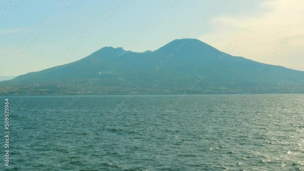 Stunning view of the Mediterranean Sea with crystal clear blue water and Mount Vesuvius in the background filmed from a boat going in Italy. Stunning view of the Mediterranean Sea with crystal clear blue water and Mount Vesuvius in the background filmed from a boat going in Italy.