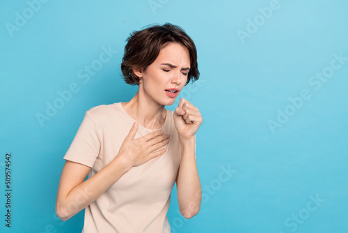 Photo of young lady have covid 19 touch her chest coughing sneezing feel bad isolated on blue color background photo