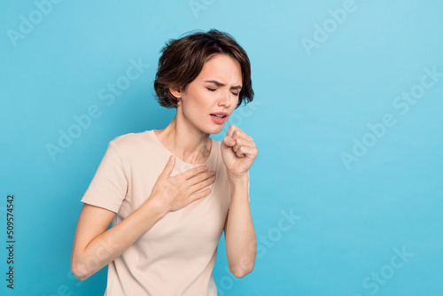 Photo of young lady have covid 19 touch her chest coughing sneezing feel bad isolated on blue color background