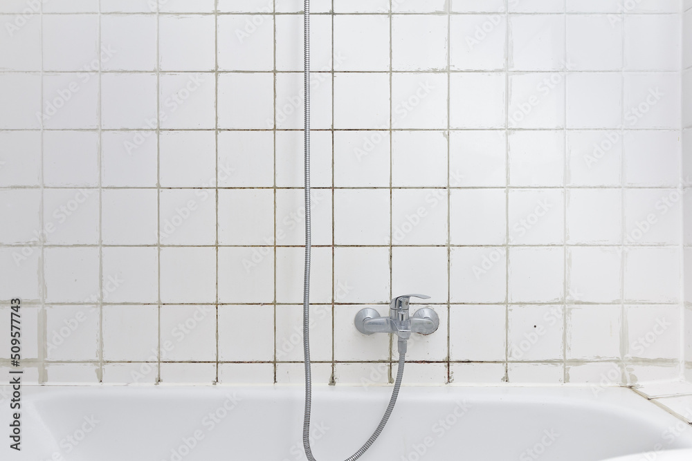 Rental damage concept grimy shower in bath tub with black mold growing