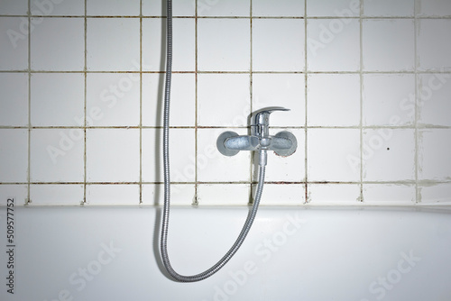 Cuadro en lienzo Spring cleaning concept: filthy shower armature in bath tub with black mold growing on calcifications on the tile grouting in an unclean old bathroom