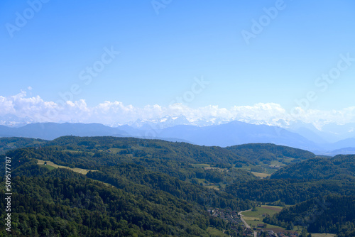 Aerial view of landscape at Canton Zürich with the Swiss Alps in the background seen from local mountain Uetliberg on a sunny spring day. Photo taken May 18th, 2022, Zurich, Switzerland. © Michael Derrer Fuchs