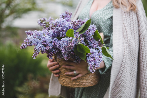 Hands of a woman in close-up with a bouquet of lilacs. Authenticity. Environmental friendliness. Content for a floral store. Sale of flowers.