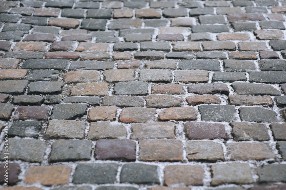 The road is paved with old cobblestones. Paving stones with snow. Winter architecture. The road is paved with old cobblestones. Paving stones with snow. Winter architecture.