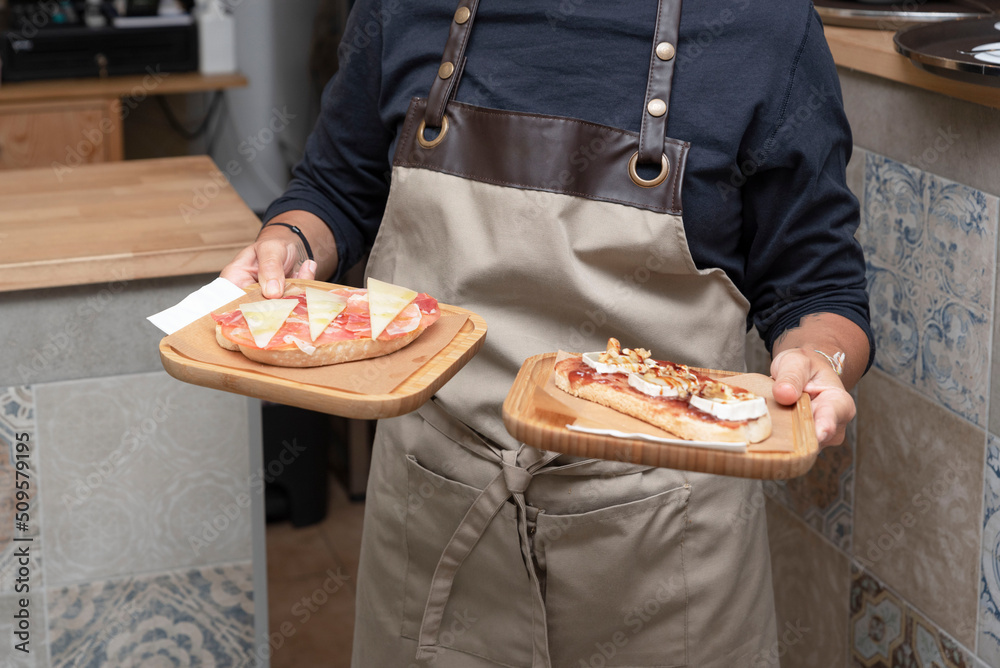 A waiter holds a wooden tray with toast, delicious brunch