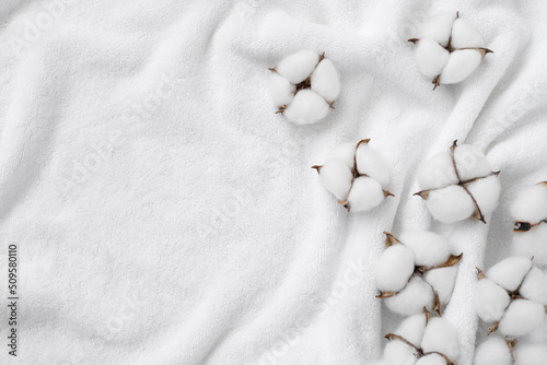 Cotton flowers on a white terry towel with copy space.