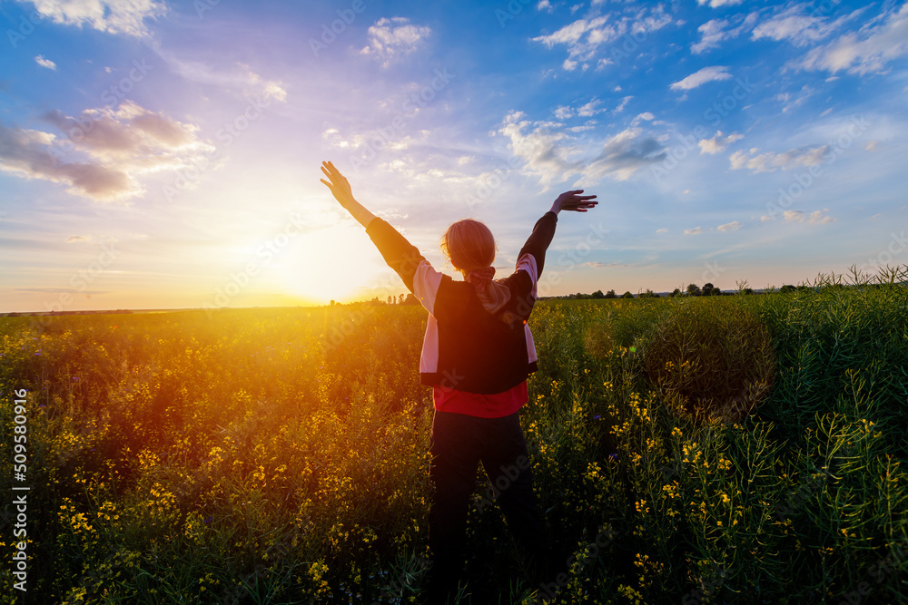 Young woman on field under sunset light. Concept of Success in life. Young woman on field under sunset light. Concept of Success in life.