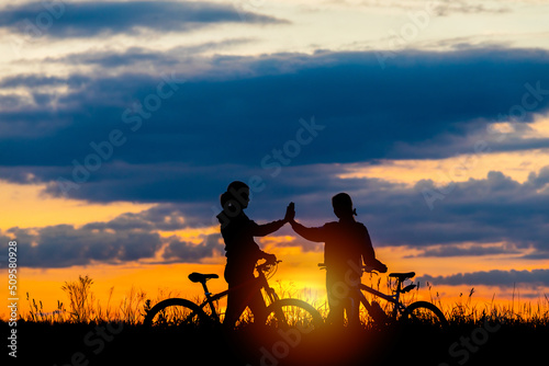 mother and little daughter riding bike at sunset.