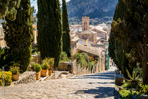 Carrer del Calvari staircase lined with cypress leads 365 steps downstairs to the old town of Pollensa with great view over rooftops to the church Santa Maria dels Àngels and mountain Puig de Maria. photo