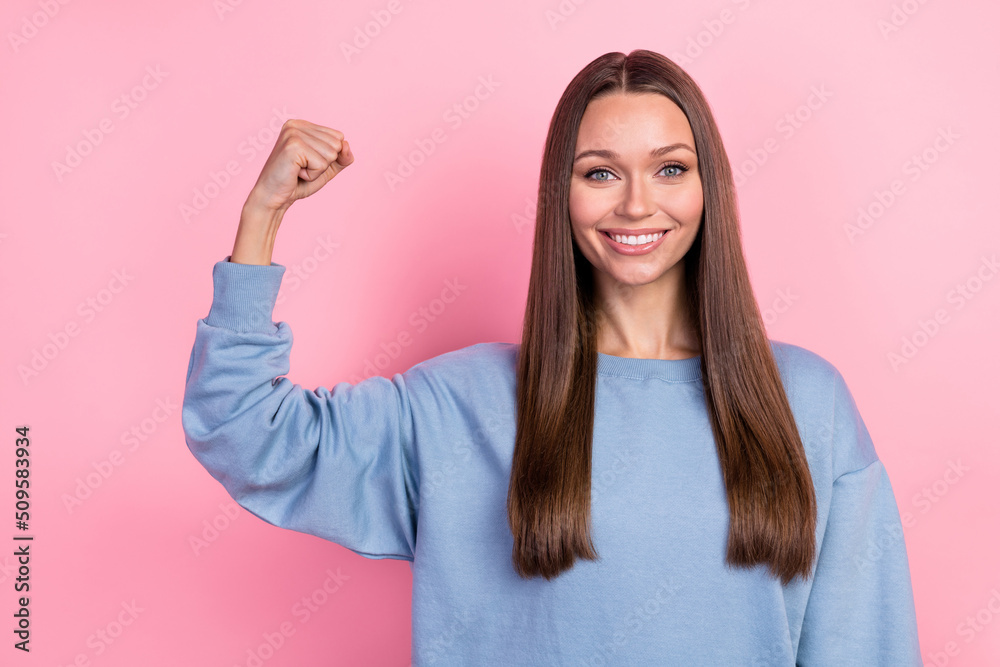Portrait of attractive girly cool cheerful girl demonstrating strong hand isolated over pink pastel color background Portrait of attractive girly cool cheerful girl demonstrating strong hand isolated over pink pastel color background