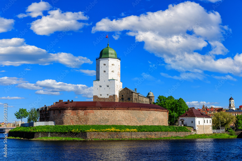 Medieval fortress in Vyborg. Castle on the water against the blue sky with clouds