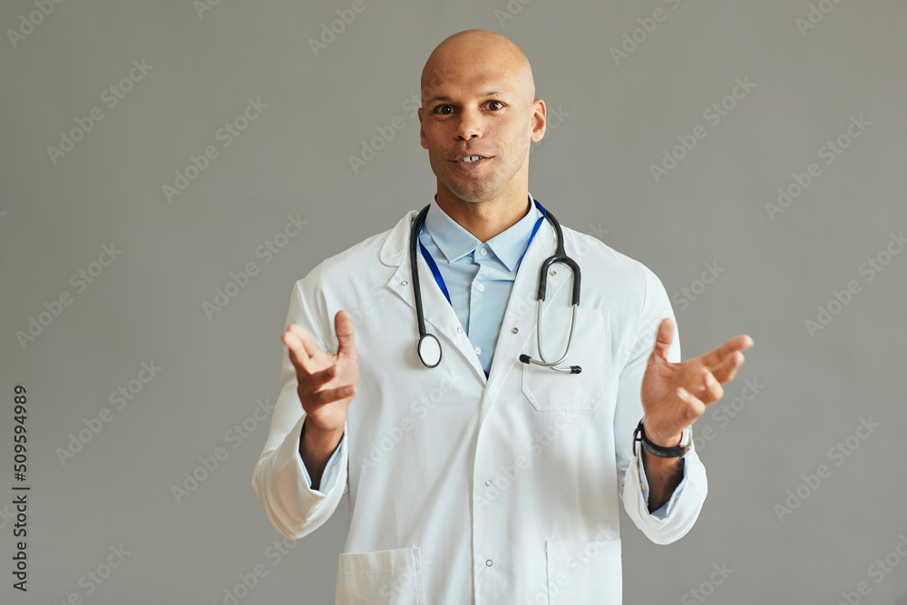 African American doctor talks while holding video conference and looking at camera. African American doctor talks while holding video conference and looking at camera.