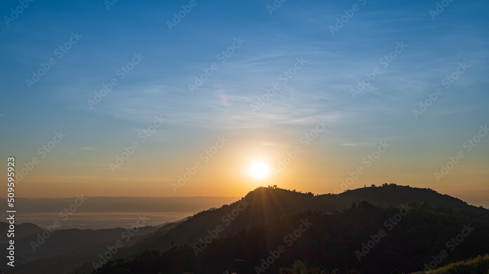 Silhouette of mountains during sunrise with sky and clouds. Beautiful natural landscape in the summertime