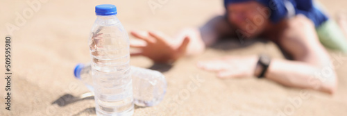 Man lying on sand in desert and feeling thirst