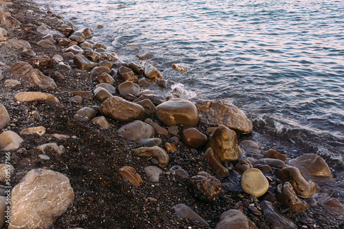  Seashore with pebbles and stones in the evening at sunset