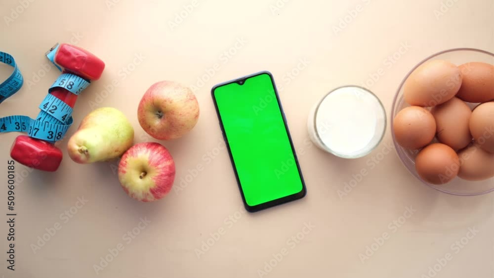smart phone with empty screen , eggs , milk and almond nut on table 