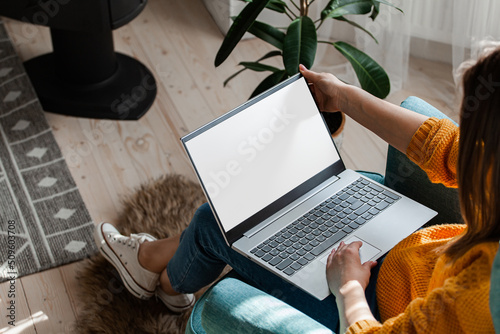Young woman using laptop to work home, remote work photo
