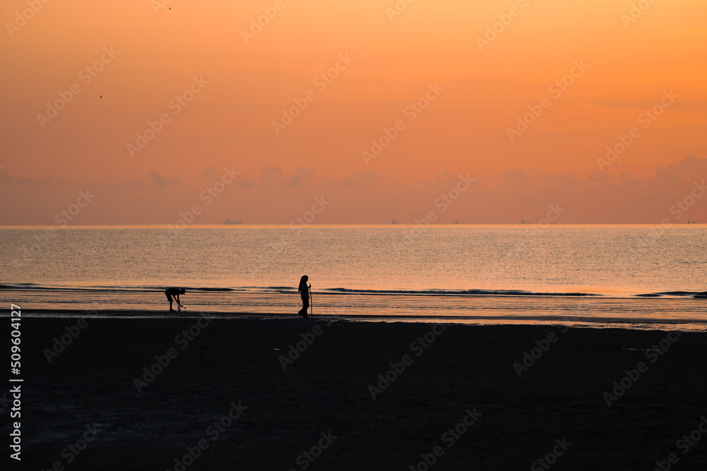 Silhouette of walking couple against sunrise..