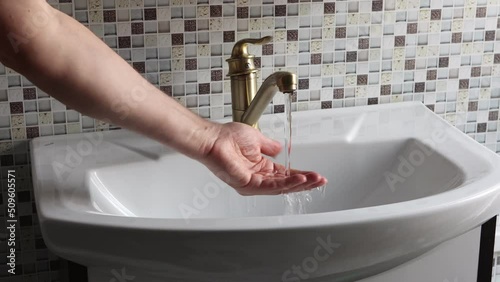 Brass single lever water faucet, hand check water temperature. photo