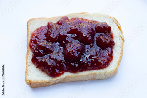 Bread with strawberry jam on white background