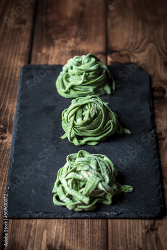 Fresh homemade spinach pasta on the black board