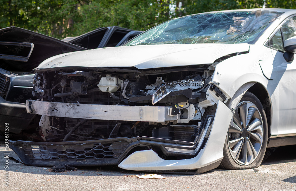 Many broken cars after a traffic accident in the parking lot of a restoration service station on the street. Car body damage workshop outdoors. Sale of insurance emergency vehicles at auction. Many broken cars after a traffic accident in the parking lot of a restoration service station on the street. Car body damage workshop outdoors. Sale of insurance emergency vehicles at auction.