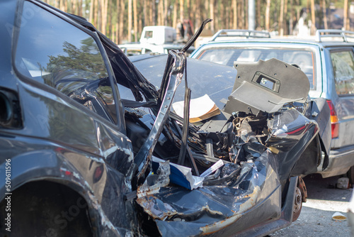 A lot of broken cars after a traffic accident in the parking lot of a repair station on the street. Car body damage workshop outdoors. Sale of insurance cars at auction.