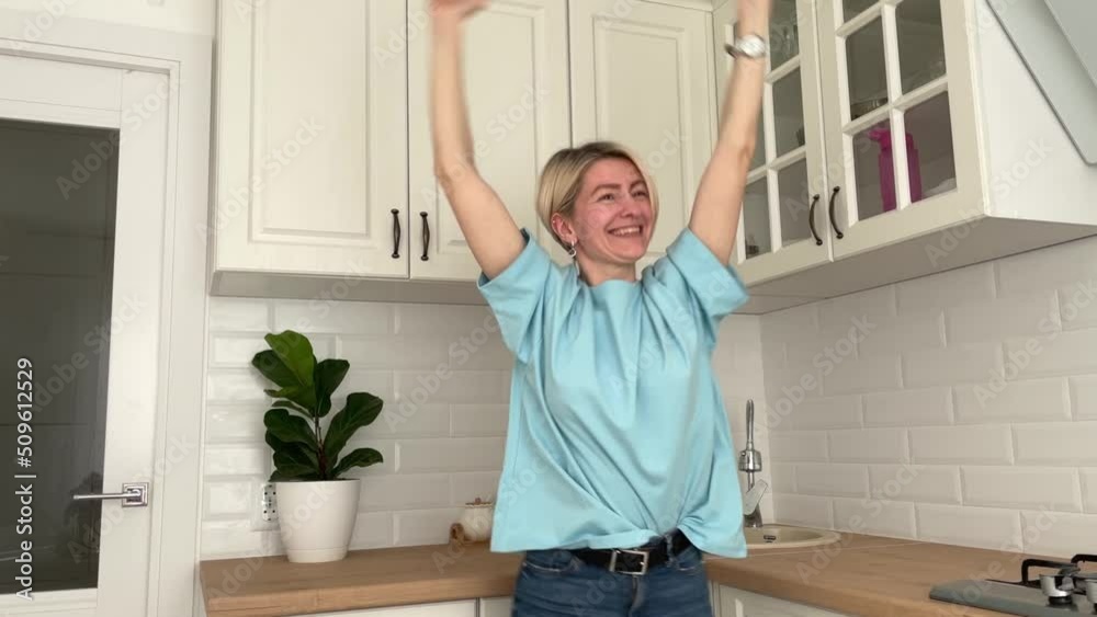 happy young girl in wireless headphones dancing in her modern kitchen, girl enjoying life listening to music happy young girl in wireless headphones dancing in her modern kitchen, girl enjoying life listening to music