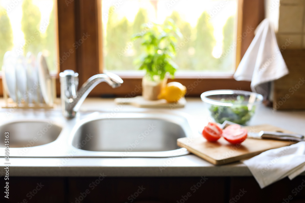 Blurred view of stylish kitchen interior with sink and products Blurred view of stylish kitchen interior with sink and products