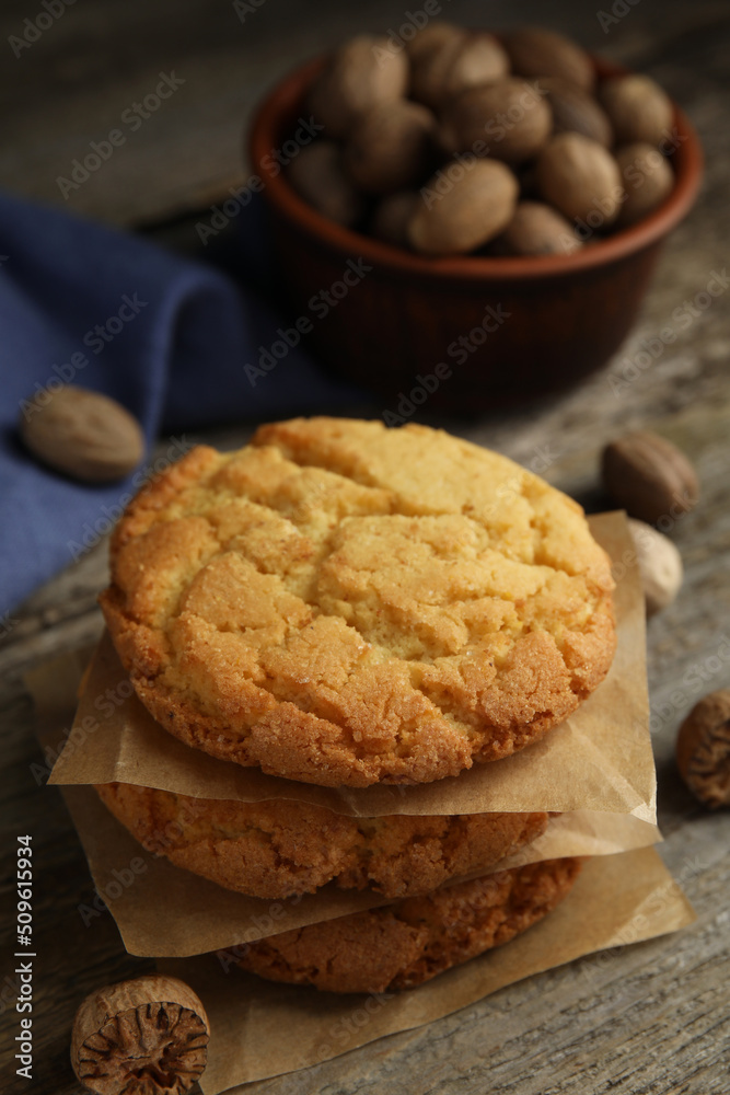 Tasty cookies and nutmeg seeds on wooden table, closeup Tasty cookies and nutmeg seeds on wooden table, closeup