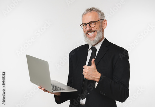 Confident caucasian mature middle-aged businessman ceo boss bank employee showing thumb up holding laptop for e-banking e-commerce, transactions with cashback isolated in white background