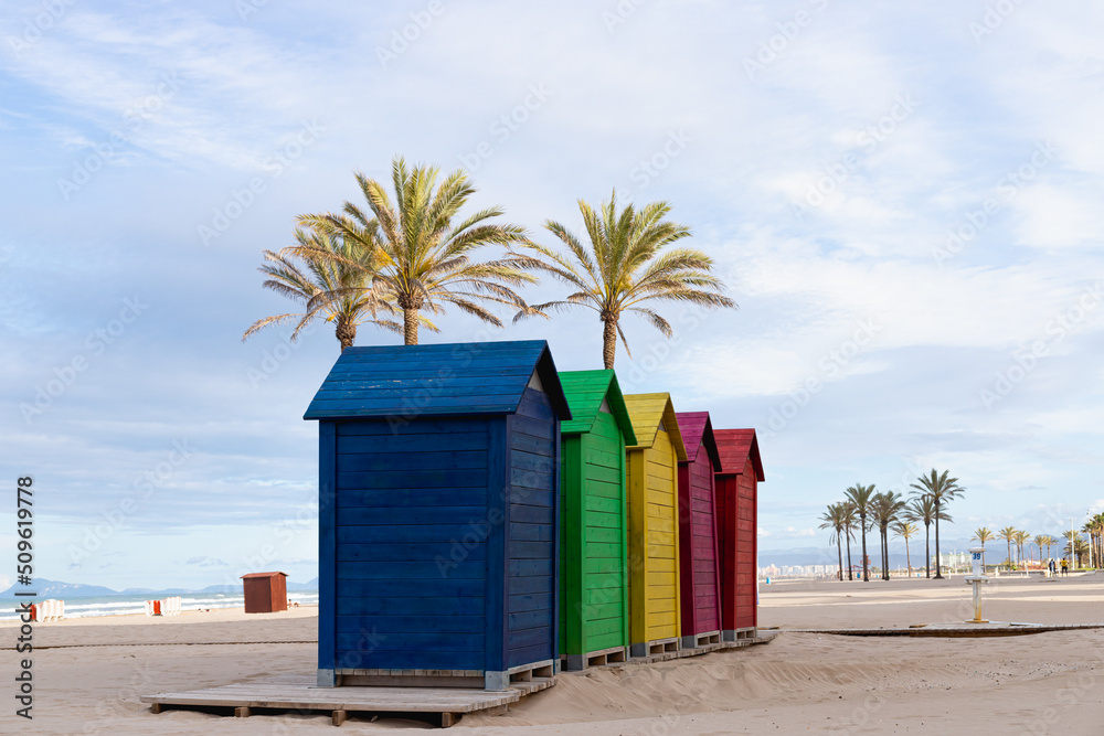 Colorful wooden houses on the beach with palm trees in the background