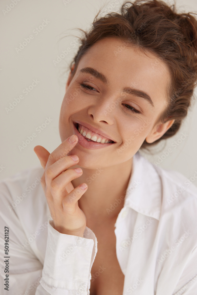 Lips care. Positive young woman with wavy brown hair using cosmetic balm for moisturizing her sexy plump lips. Skin care and beauty concept. - obrazy, fototapety, plakaty 