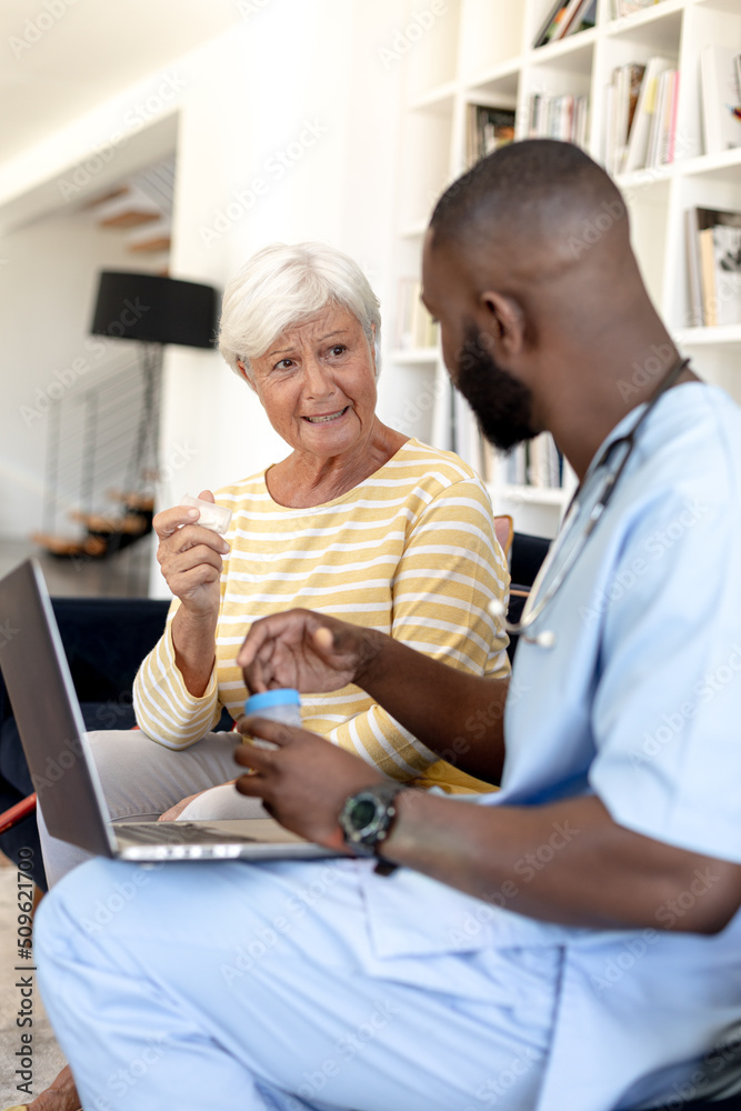 Obraz premium Male health worker with digital tablet discussing with caucasian senior woman over medication dose
