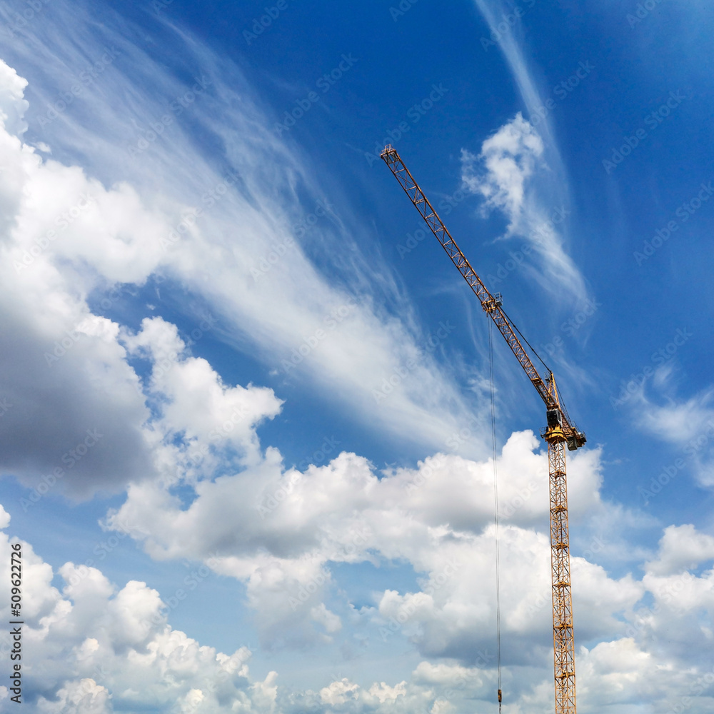 Construction lifting crane on beautiful blue sky with white clouds background. Construction lifting crane on beautiful blue sky with white clouds background.