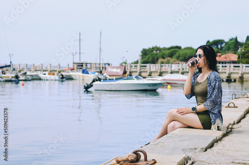 Lifestyle Portrait. Beautiful happy woman walking, relaxing, enjoying in sunny day at beach. Summer. Drinking coffee. Adriatic Sea © Oleksandra