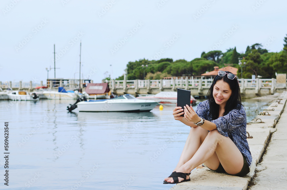 Portrait of young happy business woman relaxing, working at beach at Adriatic seaside. Using laptop. Technology. Video call. Summer vacation. 