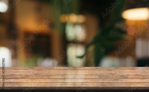 Empty wooden table top with lights bokeh on blur restaurant background. 