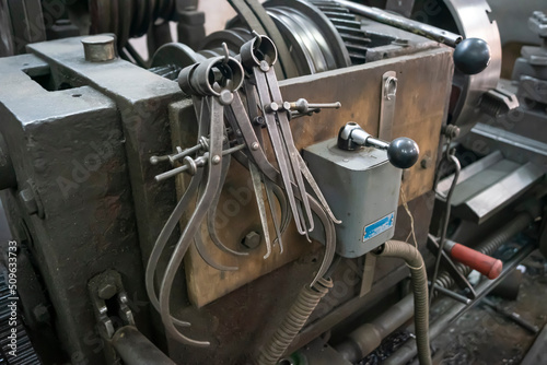 Closeup of a measuring special equipment like calipers  dividers   compass of old Lathe Machinery. Vintage Industrial Machinery in a old factory. Selective focus.  