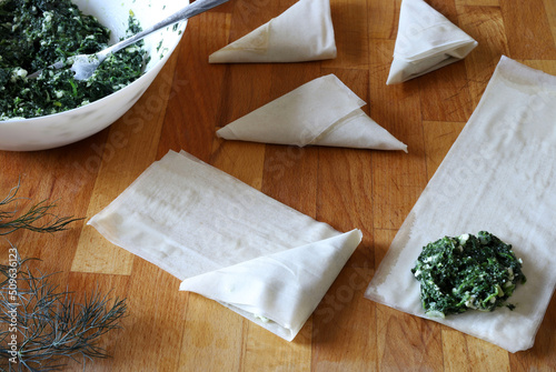 Preparare i tradizionali triangoli di torta di spinaci greci chiamati Spanakopita. Direttamente sopra.