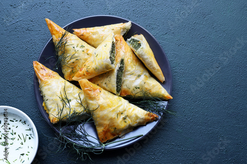 Cucina tradizionale greca. Spanakopita, triangoli  croccanti di pasta fillo con spinaci e feta. Direttamente sopra. photo
