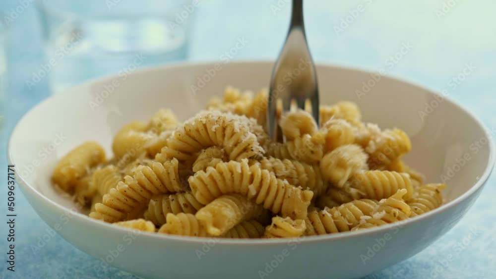 Man eating a Plate of pasta with pesto Genovese, with fresh basil, olive oil, garlic and pine nuts Man eating a Plate of pasta with pesto Genovese, with fresh basil, olive oil, garlic and pine nuts