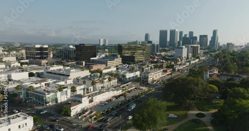 Flying Above Beverly Hills, Aerial Drone Footage of Busy City with Trees and City Skyline on Horizon