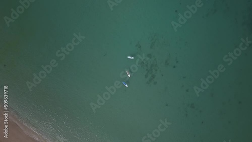 Descending aerial view of paddle boarders enjoying a sunny day in Oahu photo