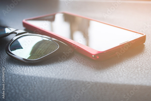 Sunglasses, phone, front of the car console with sunlight
