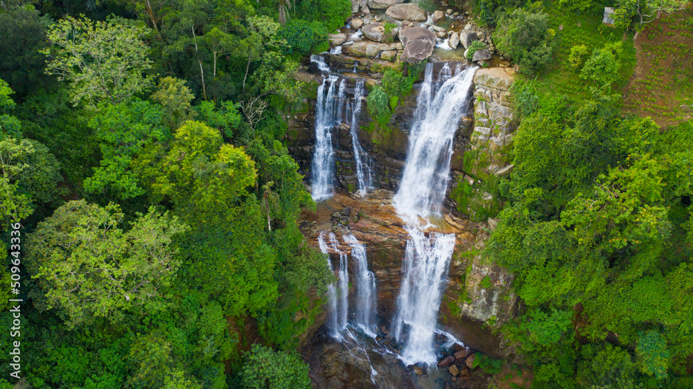 A tropical waterfall in a mountain canyon surrounded by jungle. Lower Ramboda Falls. Sri Lanka.