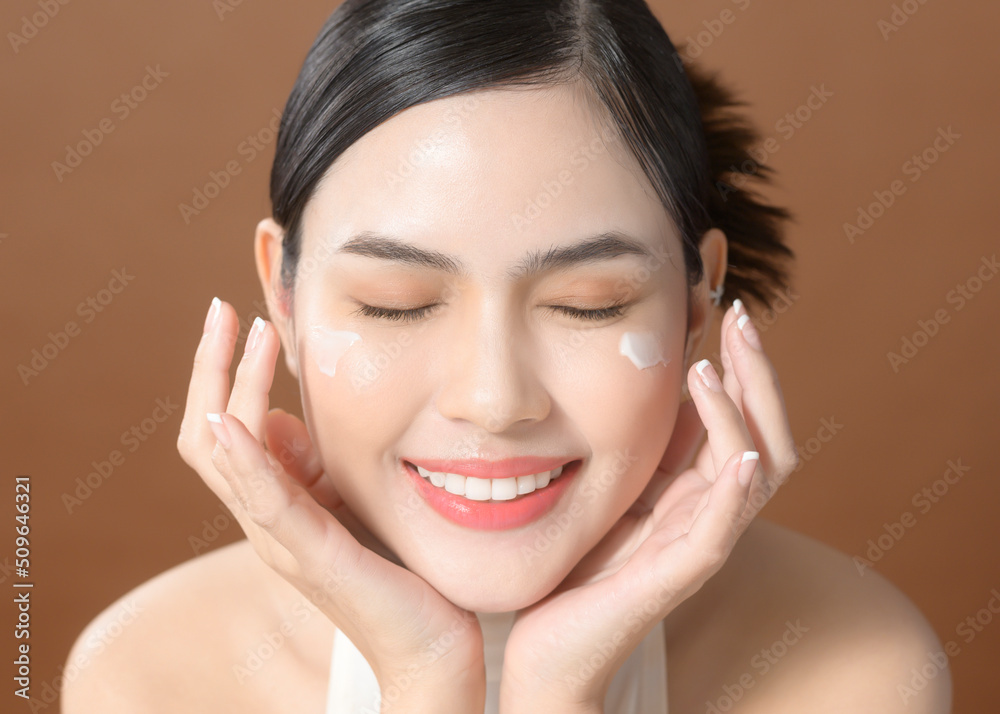 A young woman with beautiful face is holding cream , using cream of her face , beauty skin care concept