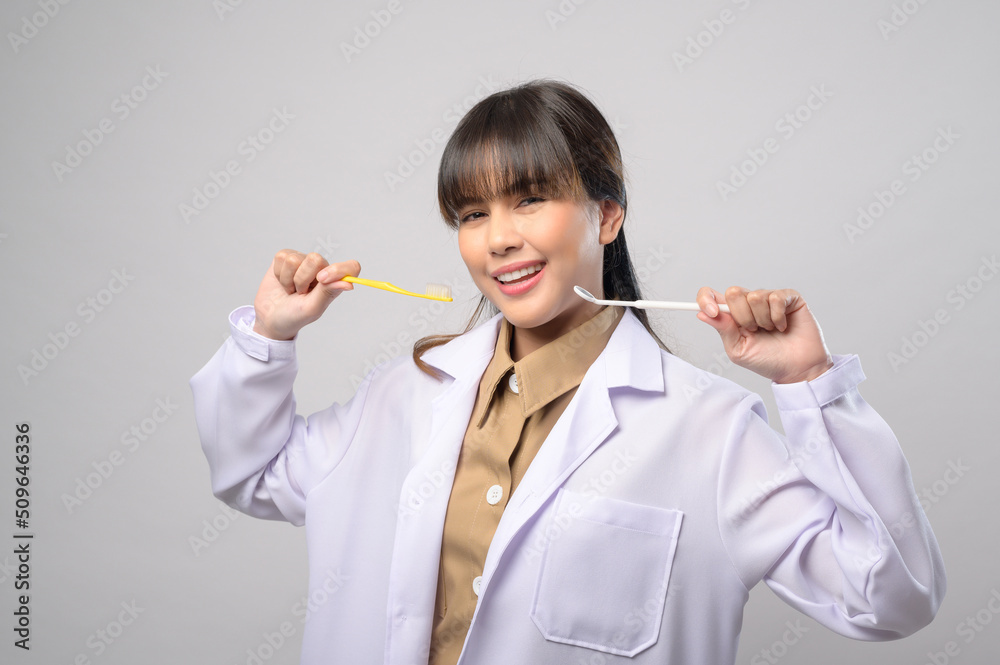 Young female dentist smiling over white background studio Young female dentist smiling over white background studio