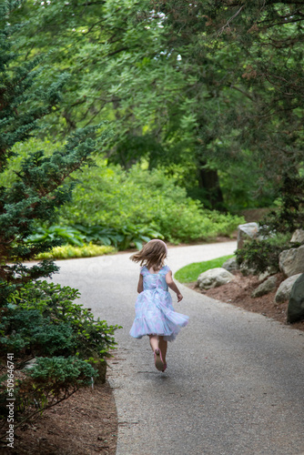 Girl running down pathway in garden